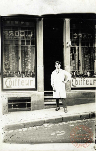 [Algrange - Coiffeur devant sa boutique]