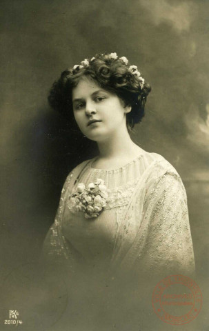 [Portrait d'une jeune femme portant une boutonnière de fleurs et des fleurs dans les cheveux]