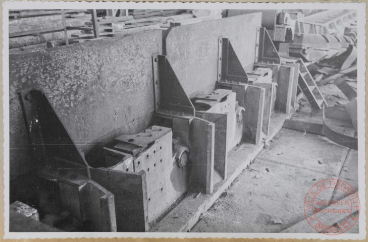 Train continu à largets et billettes. Empileur à largets. Ce bâti est cassé. Il est réparé grossièrement avec des brames.