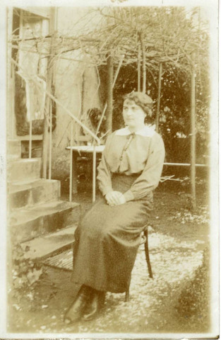 [Photographie d'une femme assise sur une chaise à l'extérieur en 1915]
