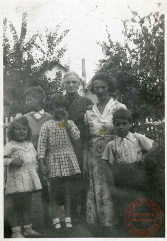 Portrait d'une famille posant dans une cour de maison