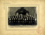 [Groupe de jeunes filles et garçons posant en 1937 pour la confirmation avec le pasteur von der Heyden à Hagondange lors du dimanche des rameaux]