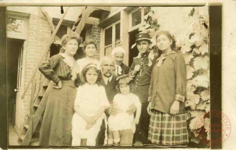 Famille posant devant un maison