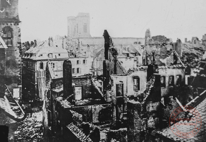 [Coin de la rue Neuve et de la rue de Paris après les bombardement de 1870. Dans le fond l'église Saint-Maximin]