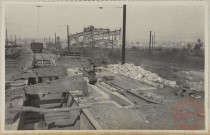 Bascule de la Fentsch. On a dans le fond une vue d'ensemble du parc à scories. Au premier plan les vestiges de la bascule principale pour les wagons rentrant à l'usine, dite "bascule de la Fentsch". C'est un bombardement aérien en mai 1944 qui l'a démolie.