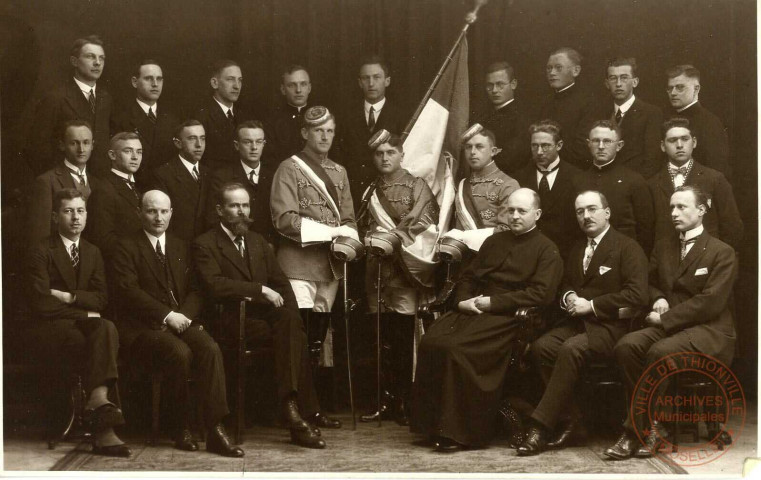 [Groupe d'hommes dont trois tenant une épée et un porte-drapeau]