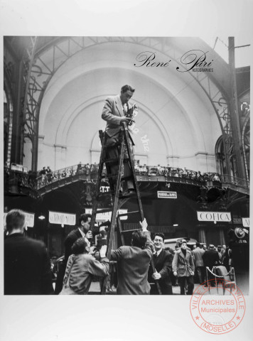 Le photographe René Pari, équipé de son Rolleicord f:75, ouverture 3,2 au salon de l'auto en 1949