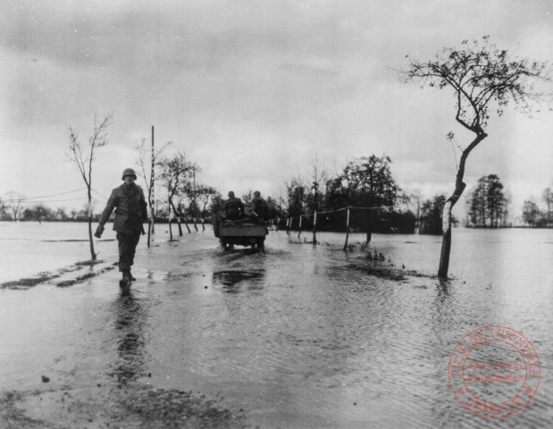 Des hommes du 991st Engineer Bataillon de la 90th Infantery Division se préparent au franchissement de la Moselle qui a débordé, près de Gavisse, en novembre 1944