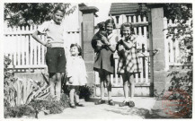 4 enfant et 1 chien posent dans la cour d'une maison