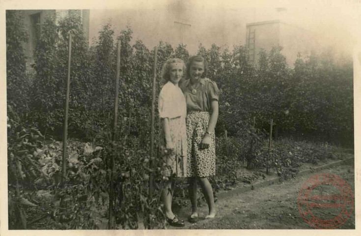 2 jeunes femmes posent devant un jardin potager