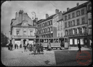 [Place du Marché, le tramway et des passants. On peut y voir plusieurs commerces, la bijouterie Gierden frères, photographie Bruère, confections pour hommes, dames et enfants et Charles Bernheim]