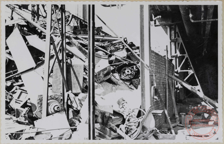 Parc à riblons. Une extrémité donnant une petite idée de l'encombrement du parc, avec des ferrailles non classées souvent hors dimensions, mélangées aussi au point de vue qualité. Le mur de bordure que l'on aperçoit cède sous le poids des ferrailles et il est soutenu par des perches formant arc-boutant.